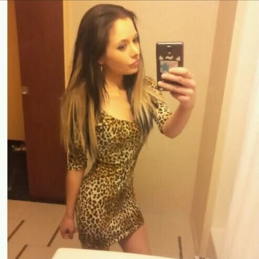 Jennifer Jorgensen Ahmed in a leopard print dress taking a bathroom mirror selfie