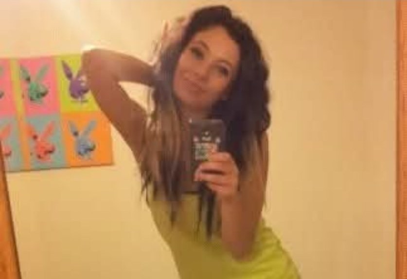 Jennifer Jorgensen Ahmed in a neon yellow dress posing for a mirror selfie