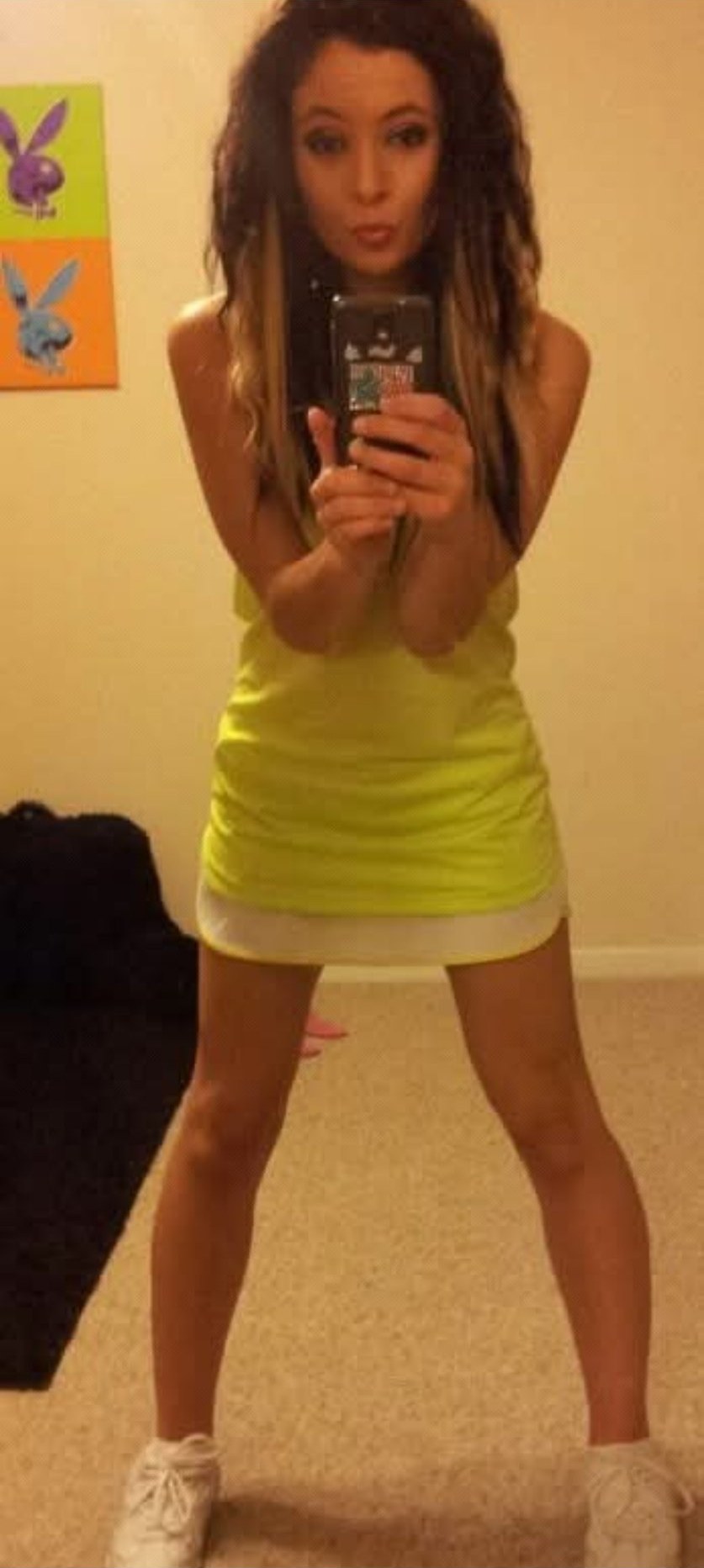 Jennifer Jorgensen Ahmed in a neon yellow dress taking a mirror selfie
