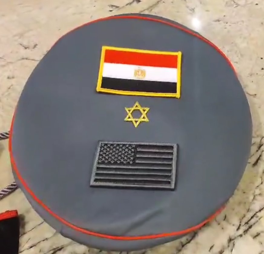 Jennifer Jorgensen Ahmed's grey insignia cover with red piping — Egyptian flag patch, gold Star of David, and black United States flag patch